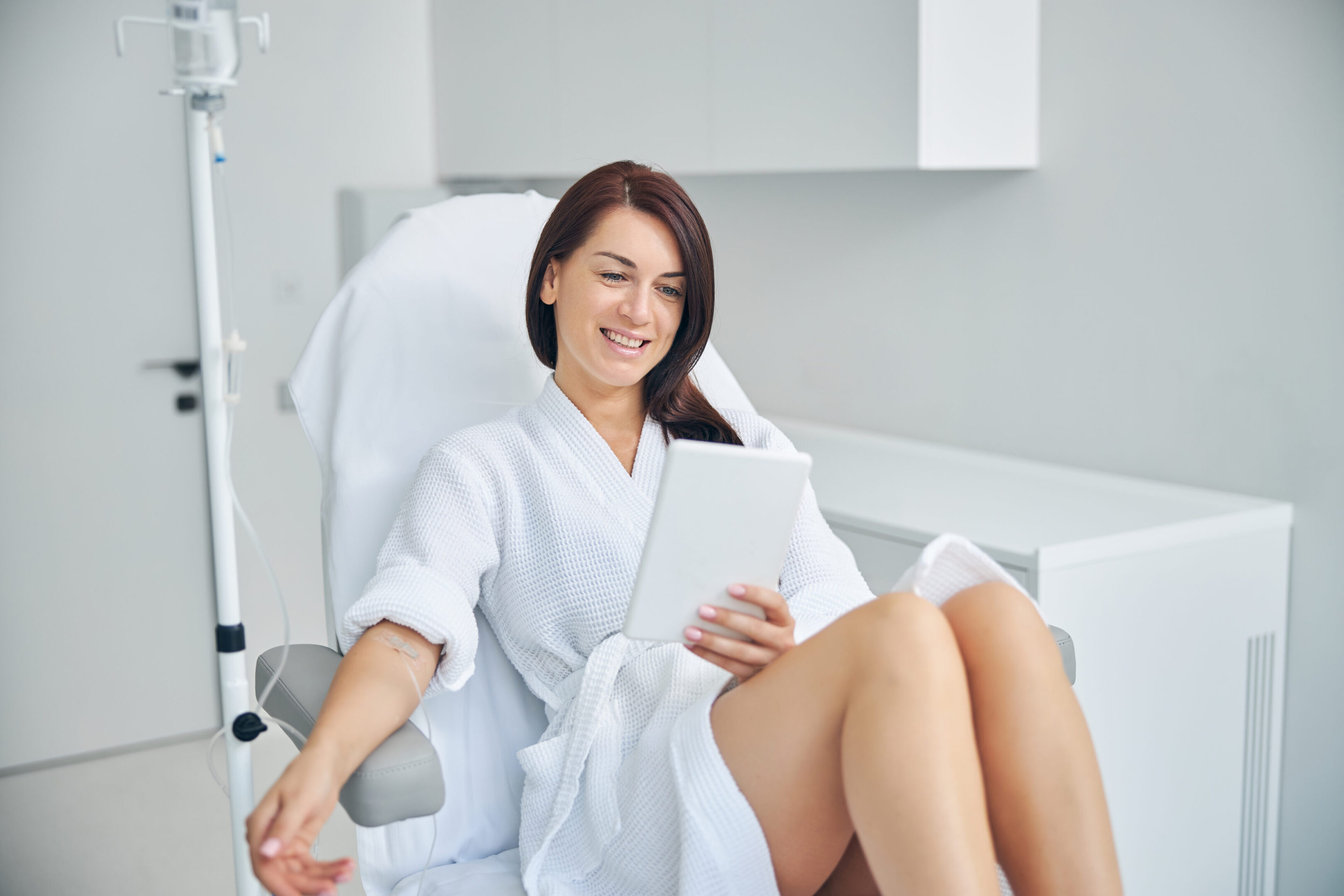 Woman relaxing with a tablet in clinic.