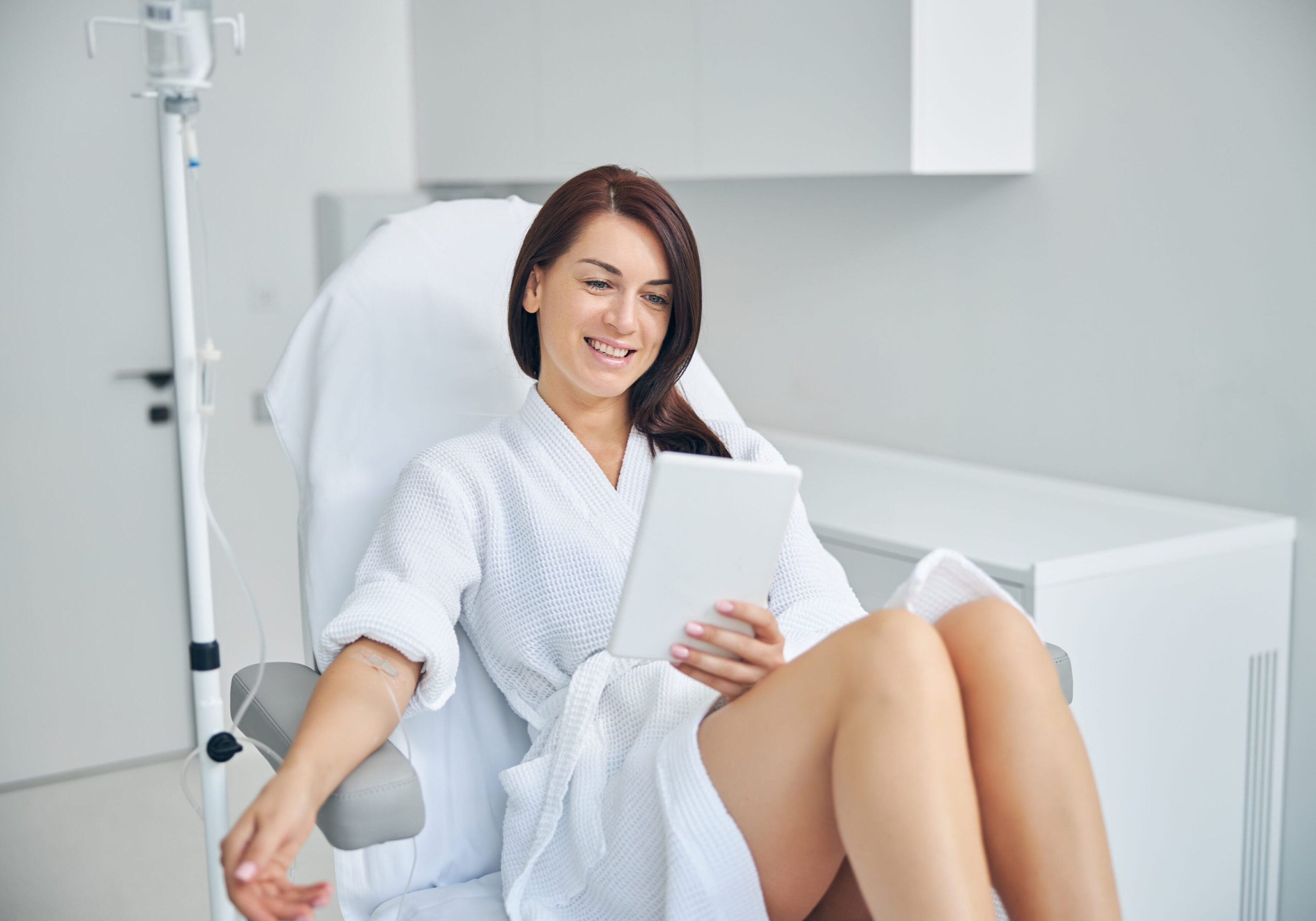 Woman relaxing with a tablet in clinic.